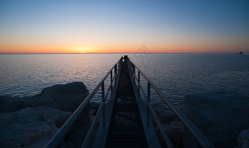 当太阳升到地平线时密歇根湖上空有一条捕鱼平台假期高清图片素材
