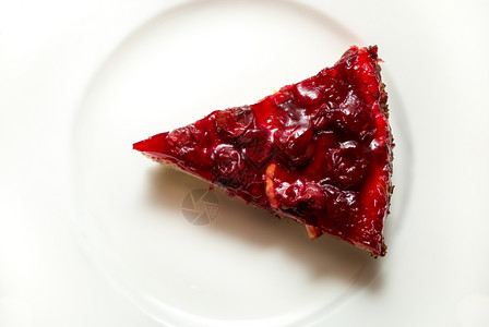 白盘上美味樱桃芝士蛋糕切片的近镜头图片