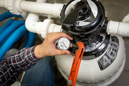 水管人员检查大型液压泵的力计近镜头图片