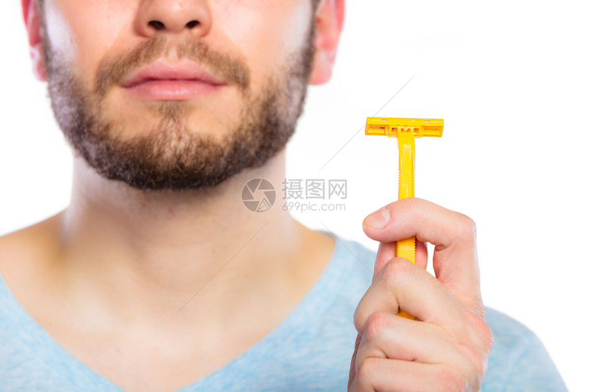 长胡子的年轻人展示一次黄色剃刀片制厂拍摄的白色背景图片