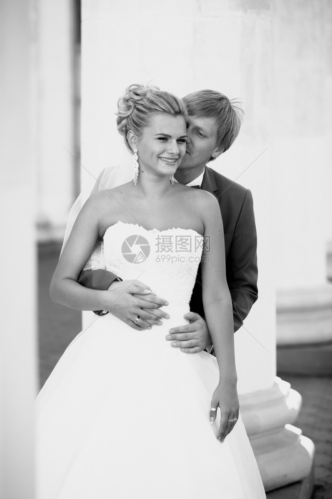 年轻新郎拥抱背上微笑的新娘黑白画像图片