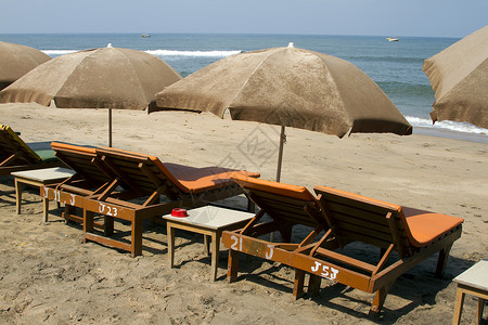 印度果阿海滩上的木板床和遮光罩背景