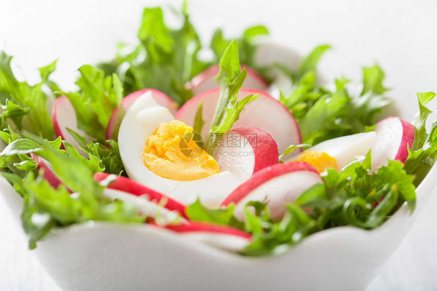 健康沙拉配有鸡蛋萝卜和绿叶图片