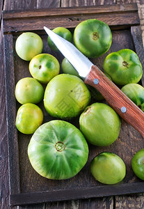 绿番茄和木板上的刀图片