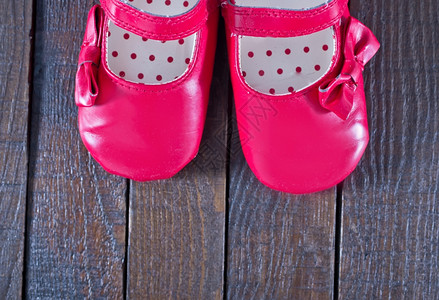 木制背景的红婴儿鞋背景图片
