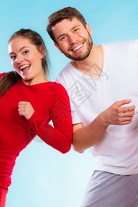 运动概念的年轻快乐情侣男女在蓝背景上玩得开心的肖像图片