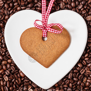 心形咖啡素材咖啡时间概念心形板和饼干姜在咖啡豆背景上贴红丝带背景