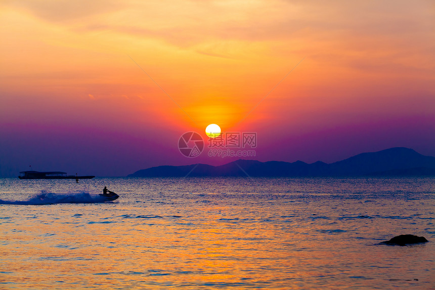 在日落时海面上有行驶的摩托艇图片