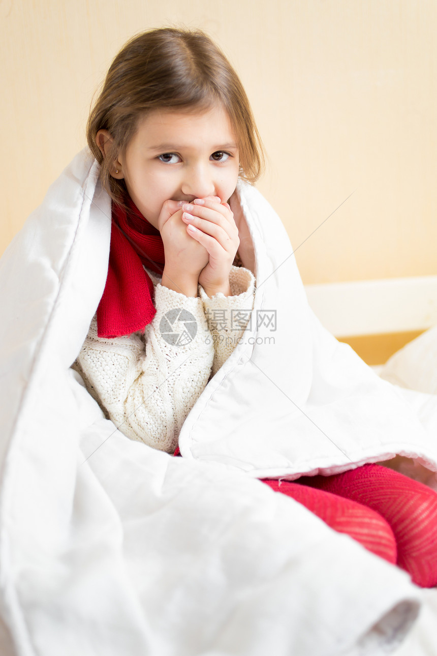 躺在床上咳嗽的被毯子包着生病女孩肖像图片
