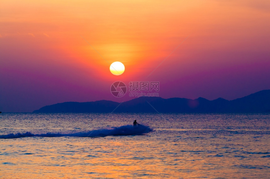 在日落时海面上有行驶的摩托艇图片