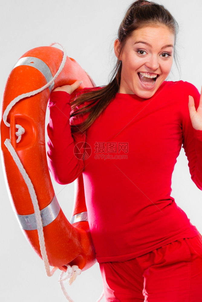 年轻女在值勤时微笑的女救生员持有浮标救生设备在灰色上玩得开心图片