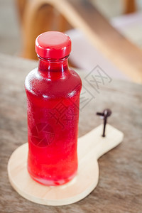瓶子里的红糖浆在木板上的瓶子库存照片图片
