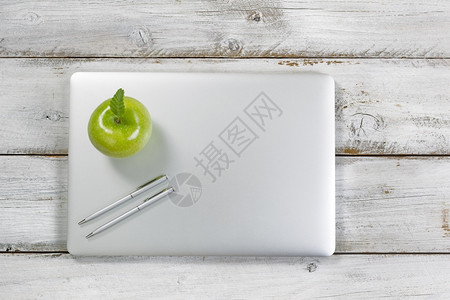 绿色苹果和银笔在记本电脑上图片