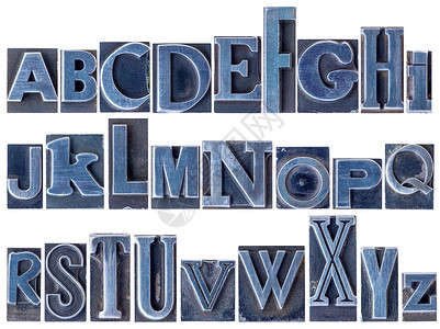 英文字母表纸印金属类刷块中26个孤立字母的拼图各种混合字体用蓝色墨水染背景图片