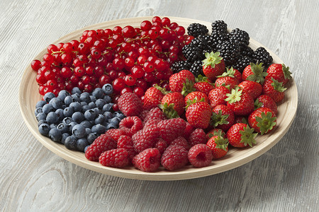 盘子上新鲜的夏季水果蓝莓草红和黑图片