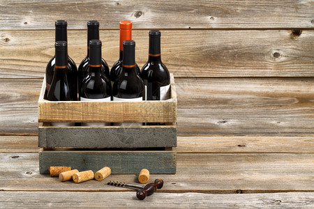 红葡萄酒瓶装在木箱里有旧的软木板在生锈上用软图片