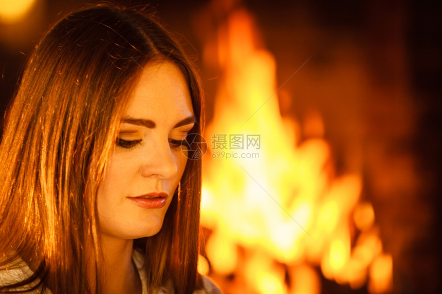 女人在壁炉里放松冬天回家女人在壁炉里休息年轻女孩暖和家里冬天图片