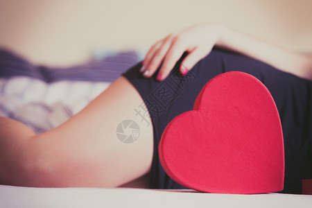红色的心脏形状盒和女人的腿情节爱图片