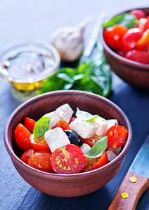 番茄和奶酪沙拉碗里和桌上的希腊沙拉背景