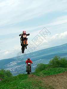 越野摩托车在山坡飞跃的镜头图片