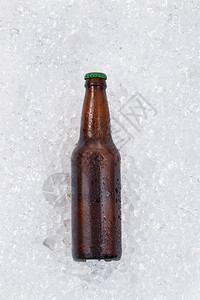 单瓶啤酒在冰堆上冷却垂直布局图片