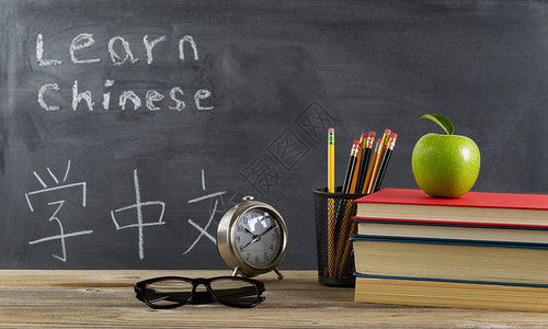 学生习中文有书籍铅笔时钟眼镜和苹果背景图片