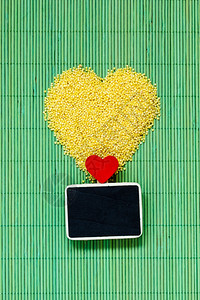 心形的米片呻吟和小黑板绿色垫子上有文字菜单的空间背景图片