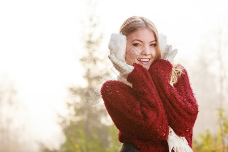 美丽的年轻女孩穿着白色耳巾和毛衣秋冬时装图片