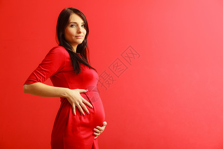 新生命概念怀孕母亲和幸福怀孕妇女肚子饿在室内穿着时装优雅的红色礼服图片