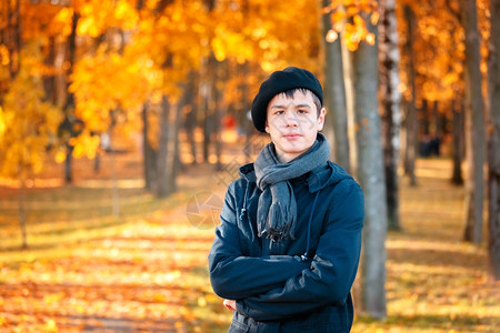 秋天阳光明媚的公园穿着贝雷帽和夹克的少年男孩图片