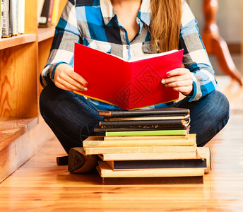 教育学校概念聪明的女学生孩坐在大图书馆的地板上阅读书本图片