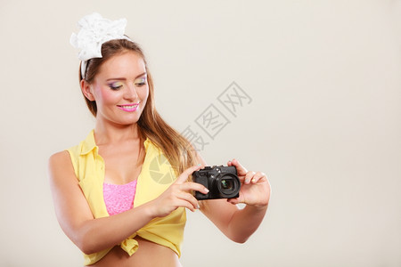 笑的漂亮女孩带着发弓拿相机拍照背景图片