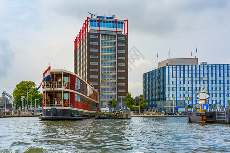 荷兰阿姆斯特丹运河船只和现代建筑的城市景象图片