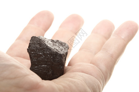 雄手中的煤块碳核糖分离在白色的电源和能量上图片