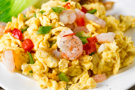 鸡蛋和虾盘选择焦点在前面虾片配有熏肉胡椒和大米背景图片