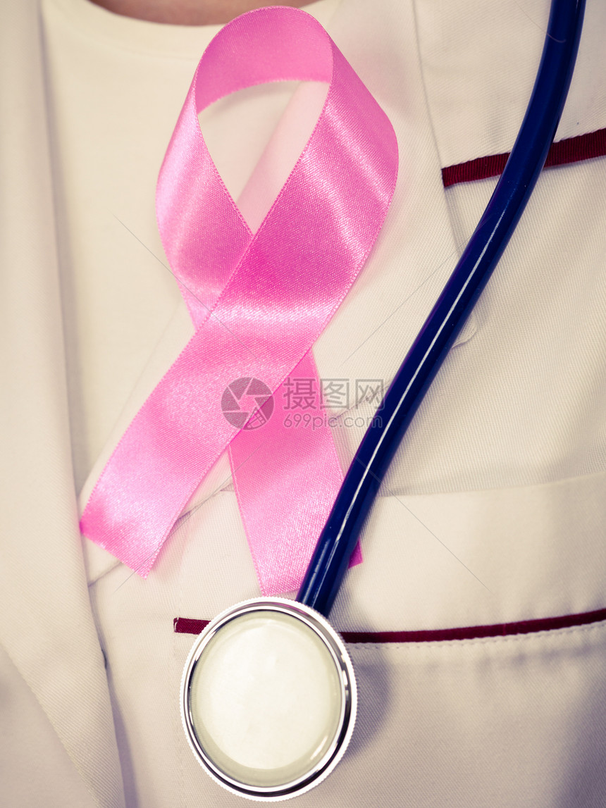 保健医药和乳腺癌认识概念胸前闭合时带有听诊器和粉色丝带辅助标志的医生图片