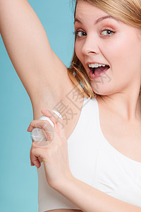 每日皮肤护理和卫生女孩在手垫中施用棒除臭剂年轻女在下臂中施用抗渗透剂蓝色青女在下臂中施用抗渗透剂紫色背景图片