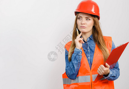 女建筑工人结构程师穿橙色背心红硬头盔的建筑工结构程师持有笔文件垫工业作安全室中工程高清图片素材