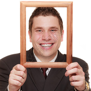 快乐的有趣生意人将他脸与白色背景隔离的木制空画框图片