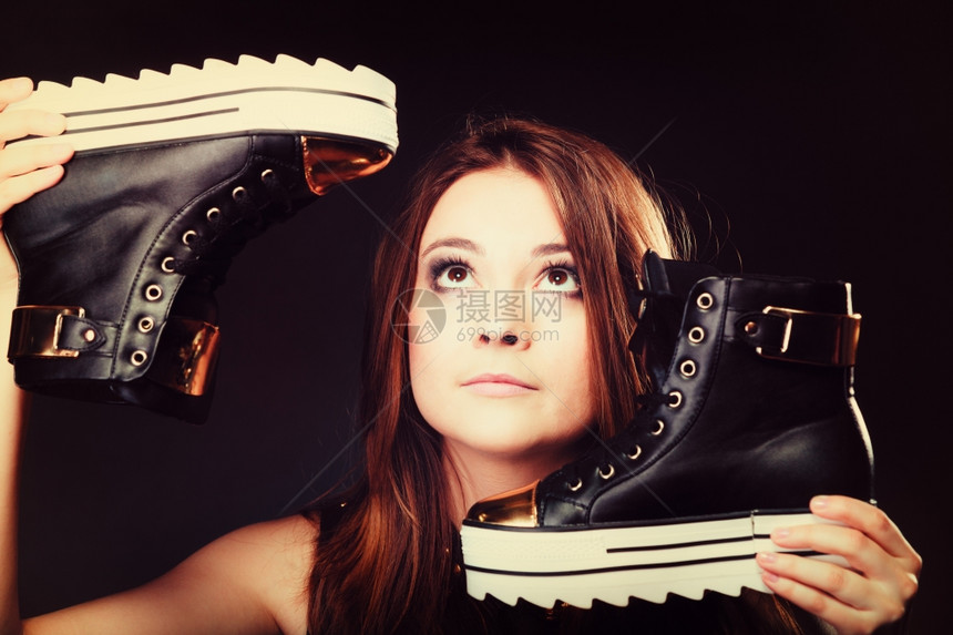 女喜欢穿鞋的青少年时装概念女模特少孩在黑色上穿着时装运动鞋图片