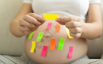 持有彩色备忘标签的年轻孕妇举办高清图片素材