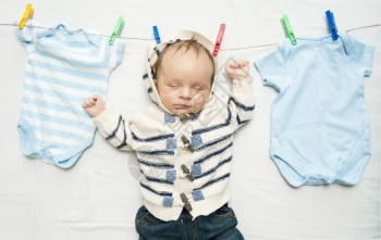 有趣的照片可爱男孩挂在衣物线上紧靠烘干衣服图片
