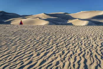 迷失在沙海中一个孤单的徒步旅行者在科罗拉多州沙丘公园的田里图片