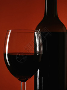 深红背景的酒瓶和杯图片
