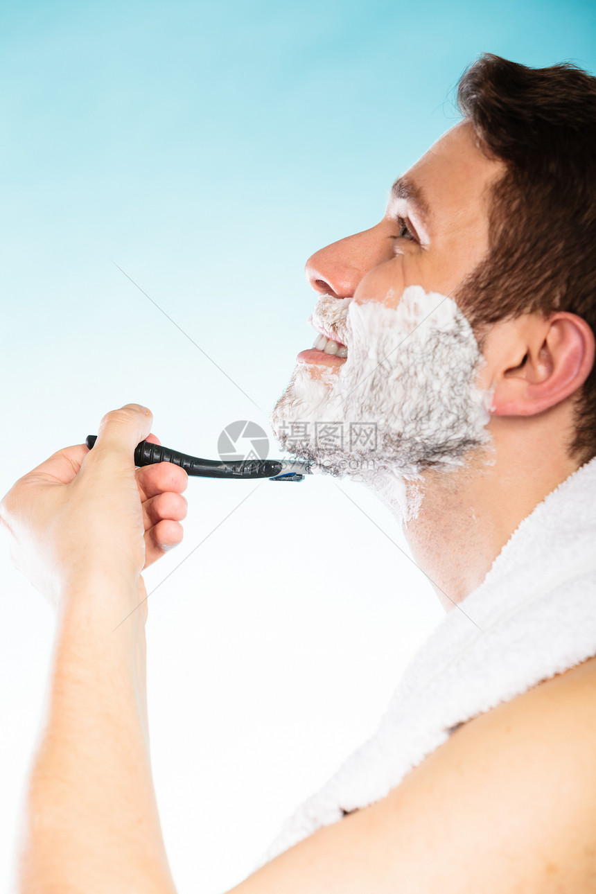 年轻人用奶油泡沫刮剃刀图片