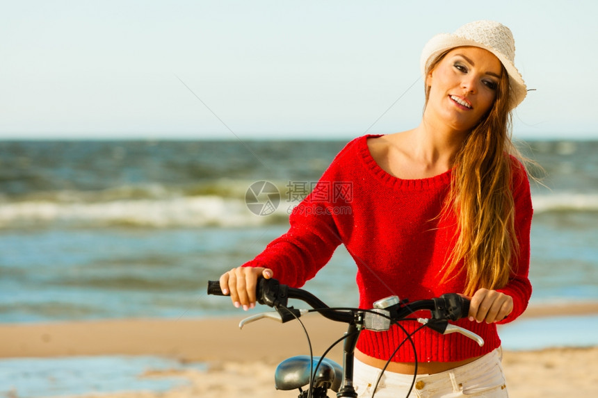 长发美女海滩上骑着自行车图片