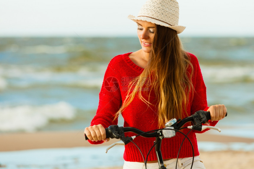 长发美女海滩上骑着自行车图片