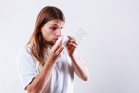 有卫生组织的人过敏和冷感概念长发有卫生组织的年轻病人吹鼻涕的家伙图片
