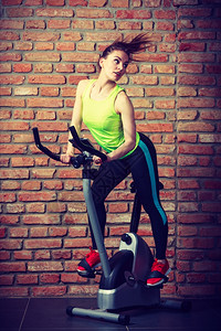 活跃的青年女子在健身房运动减体重概念图片