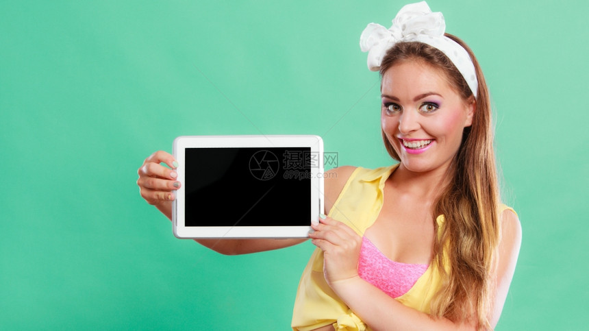 笑得开心女孩拿着平板电脑空白的屏幕复制间女雷特罗广告新的现代技术旧式时尚图片